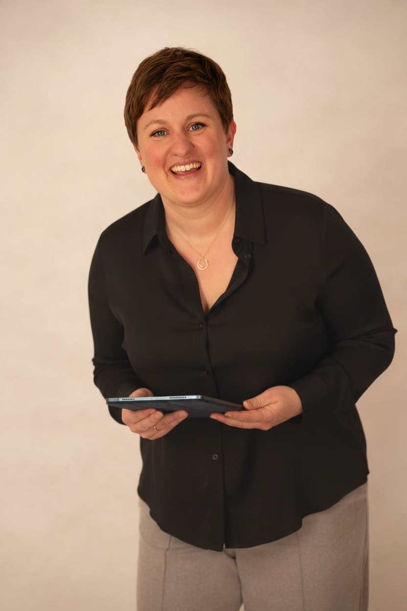 Bild von Katrin Blome, lachend, mit Tablet in den Händen